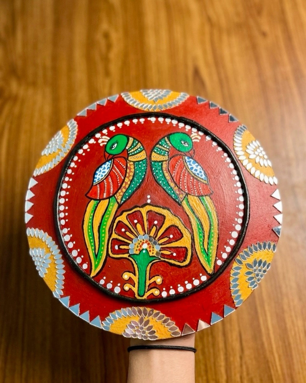 Hand-painted round folk art tava featuring twin green parrots and mirror art border