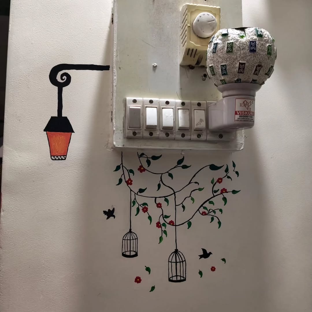 Hand-painted room accent mural with birdcages, flowers, and lantern around switchboard